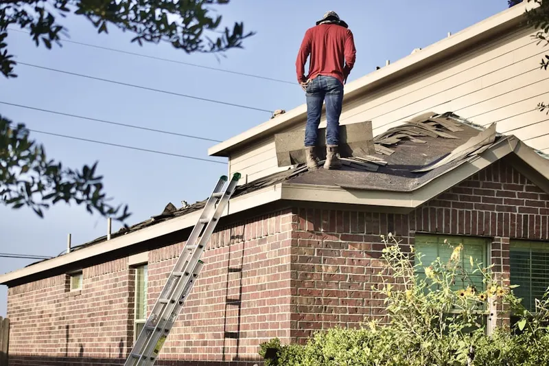 Professional roofer working on a residential roof in Parsons
